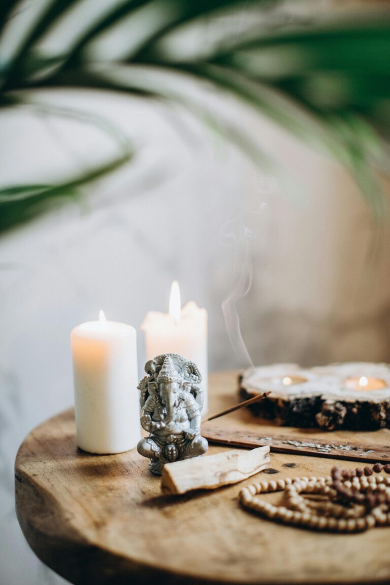 Serene still life featuring Ganesha statue, candles, and incense.