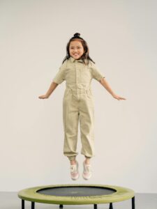 A Happy Little Girl Jumping on a Trampoline