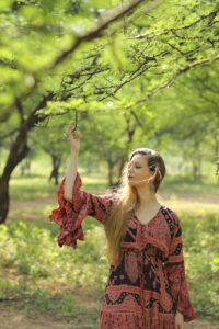 Girl leaning against a tree trunk